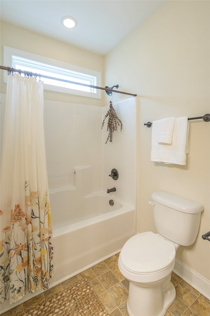 234 Streams Way Anderson, SC 29625 - Photo 18 of 44 This bathroom features a sleek bathtub, toilet, and an elegant window, offering both comfort and natural light.
