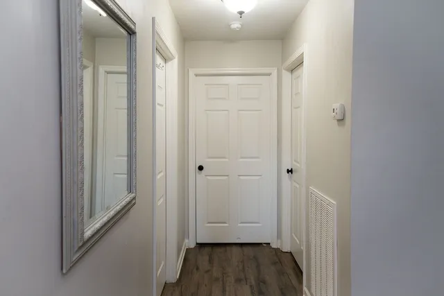 a view of a hallway with wooden floor