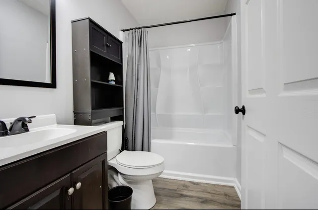 a bathroom with a sink a toilet and shower