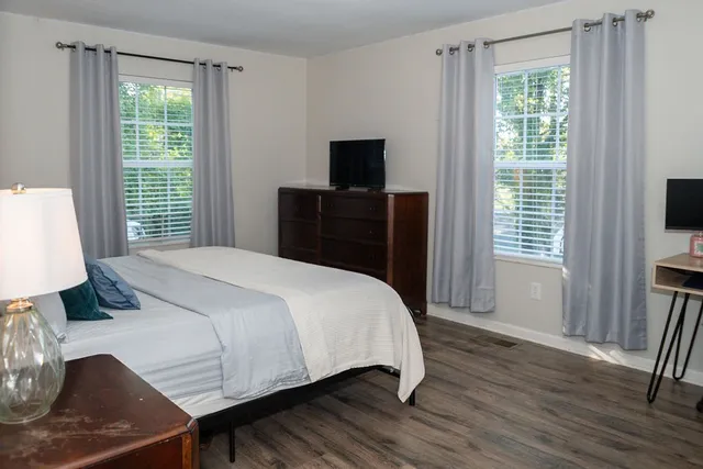 a bedroom with a bed and a flat tv screen on a dresser