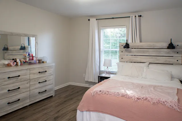 a bedroom with a bed and a dresser in it