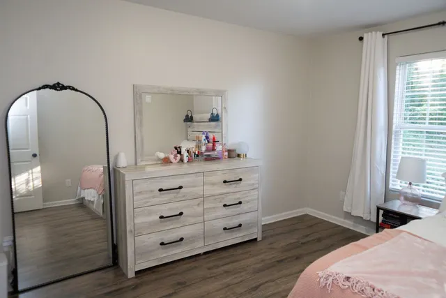 a bedroom with a bed and wooden floor