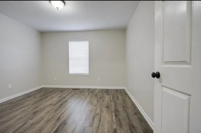 a view of a room with wooden floor and window