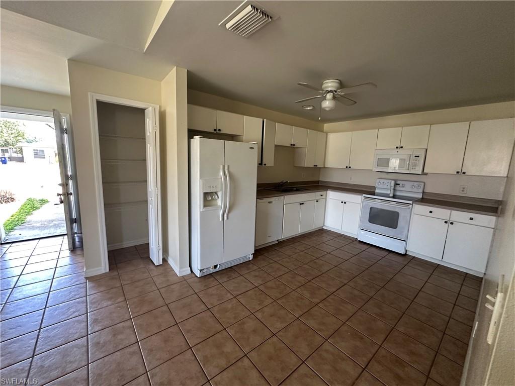 3965 20th Street West Lehigh Acres, FL 33971 - Photo 5 of 18 a kitchen with granite countertop a refrigerator and a stove top oven