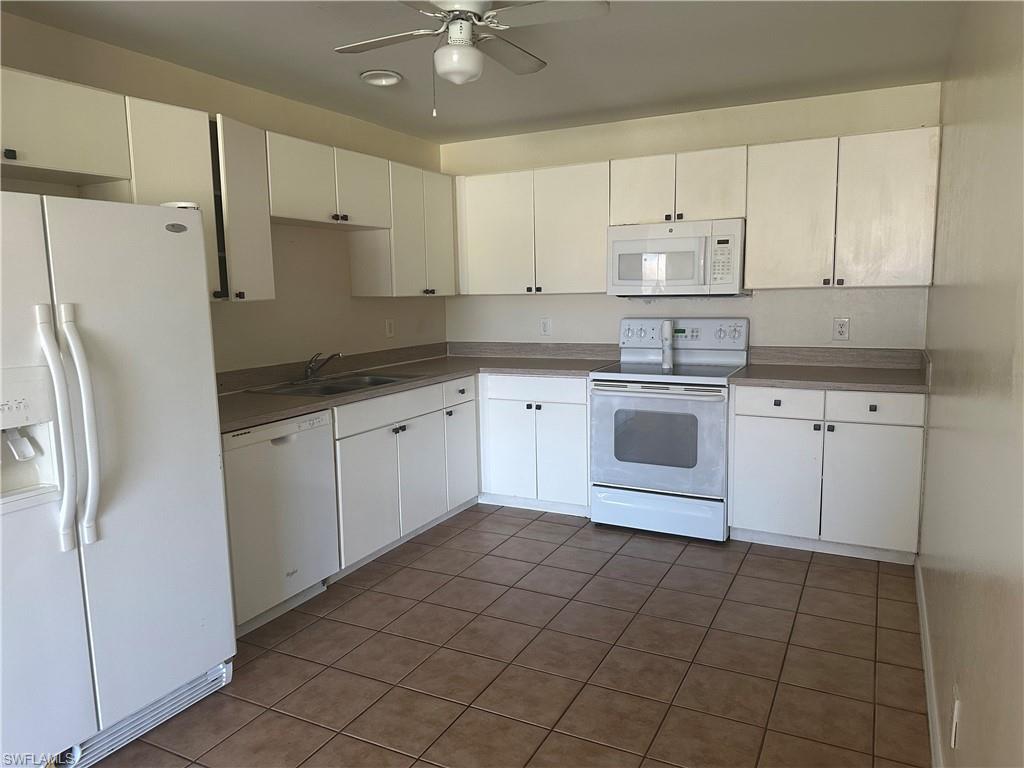 3965 20th Street West Lehigh Acres, FL 33971 - Photo 6 of 18 a kitchen with a stove sink and refrigerator