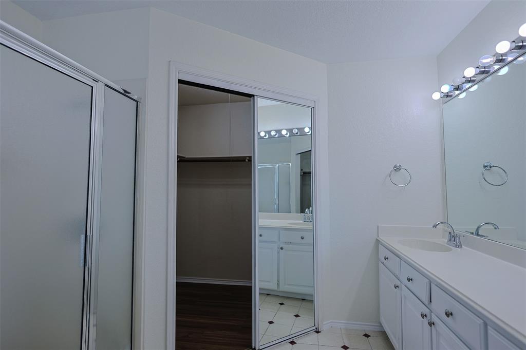 7848 Nine Mile Bridge Road Fort Worth, TX 76135 - Photo 14 of 36 a spacious bathroom with a double vanity sink a large mirror and shower