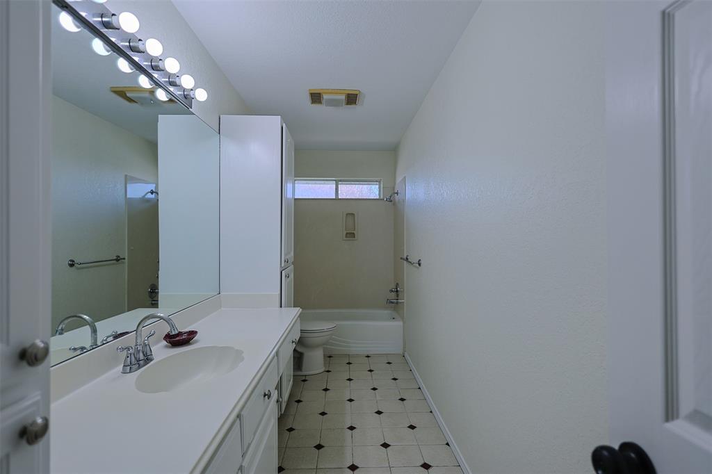 7848 Nine Mile Bridge Road Fort Worth, TX 76135 - Photo 16 of 36 a bathroom with a sink a large mirror and shower