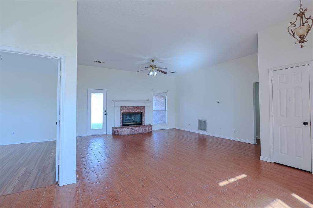 7848 Nine Mile Bridge Road Fort Worth, TX 76135 - Photo 3 of 36 a view of empty room with wooden floor and fireplace