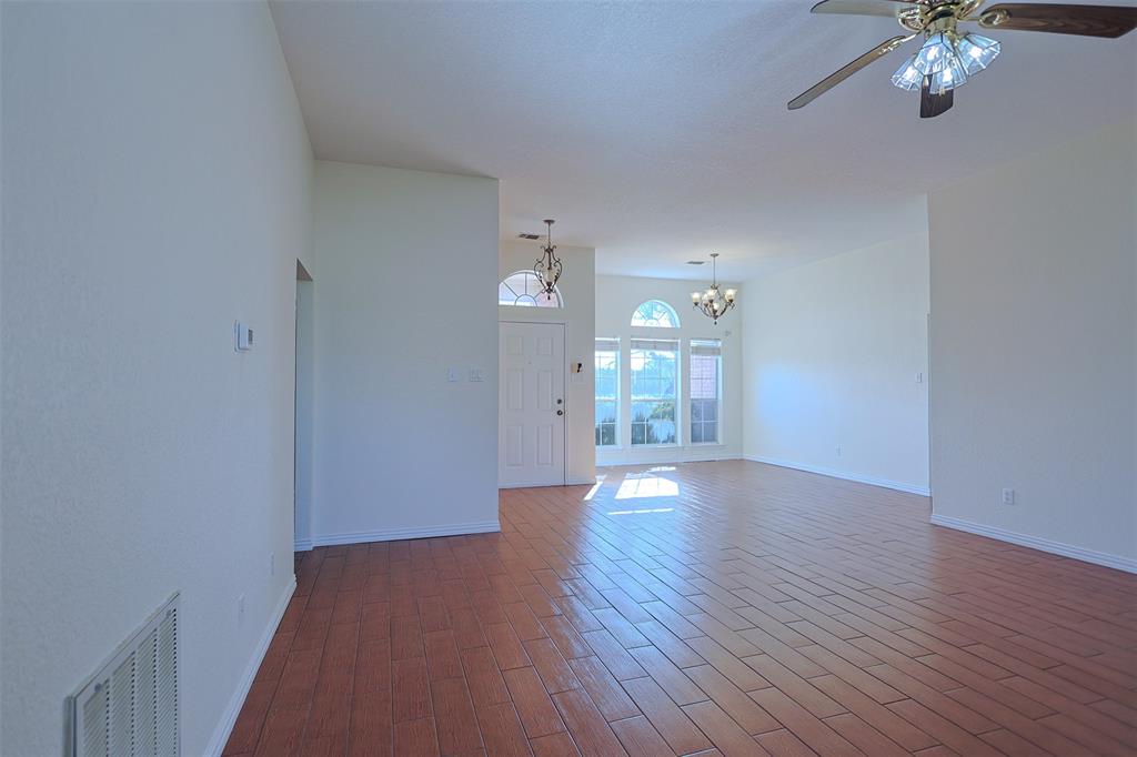 7848 Nine Mile Bridge Road Fort Worth, TX 76135 - Photo 5 of 36 a view of a room with wooden floor and a chandelier fan