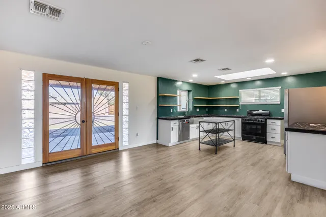 a kitchen with stainless steel appliances kitchen island wooden cabinets and dining table