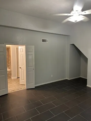 a view of an empty room with a chandelier fan