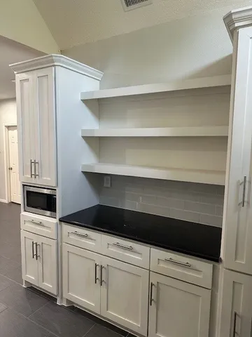 a kitchen with white cabinets and white appliances