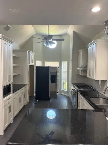 a kitchen with stainless steel appliances granite countertop a stove and a refrigerator