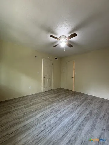 a view of an empty room with a chandelier fan