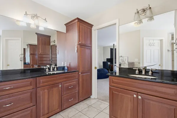 a bathroom with a granite countertop sink double vanity and mirror