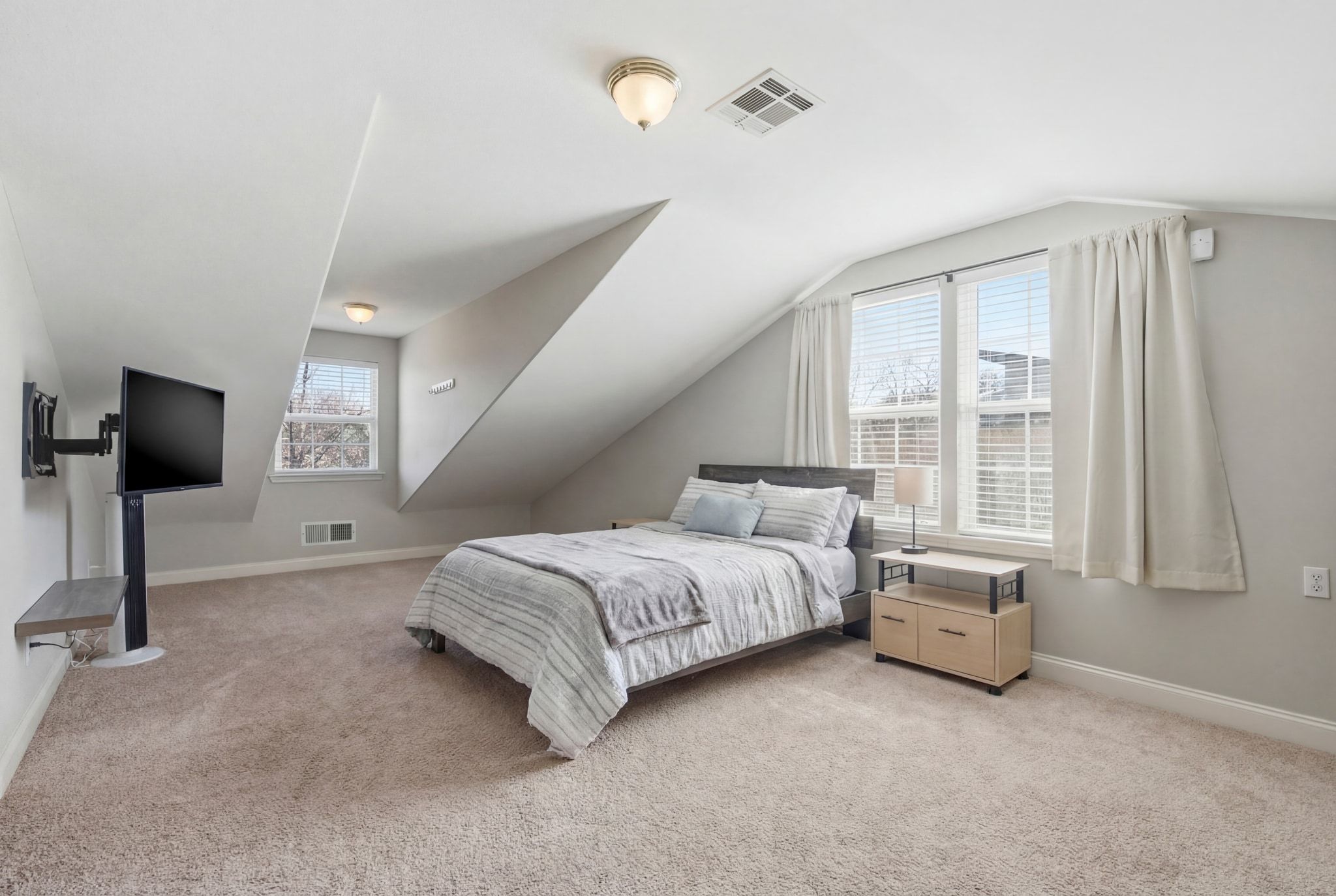 2413 Enfield Road Austin, TX 78703 - Photo 22 of 38 a spacious bedroom with a bed and a flat tv screen on dresser
