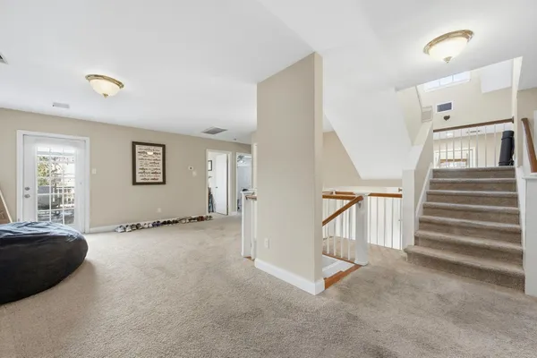 a view of an empty room with stairs and a window