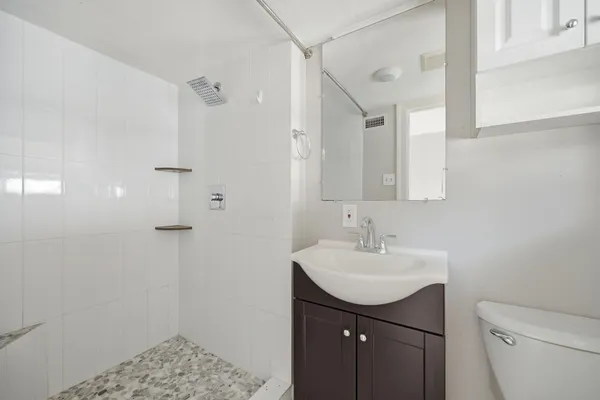a bathroom with a sink a toilet and shower
