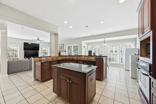 a kitchen with stainless steel appliances granite countertop a stove a sink and a refrigerator