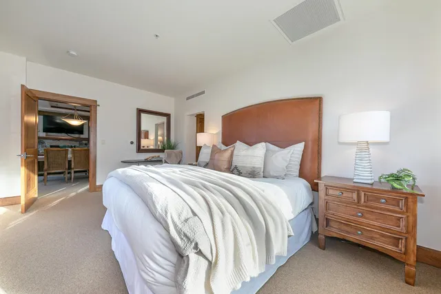 a spacious bedroom with a bed and a lamp