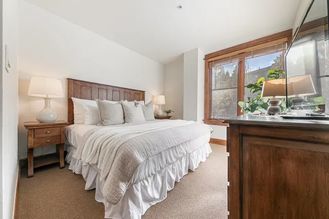 a bedroom with a bed and large window