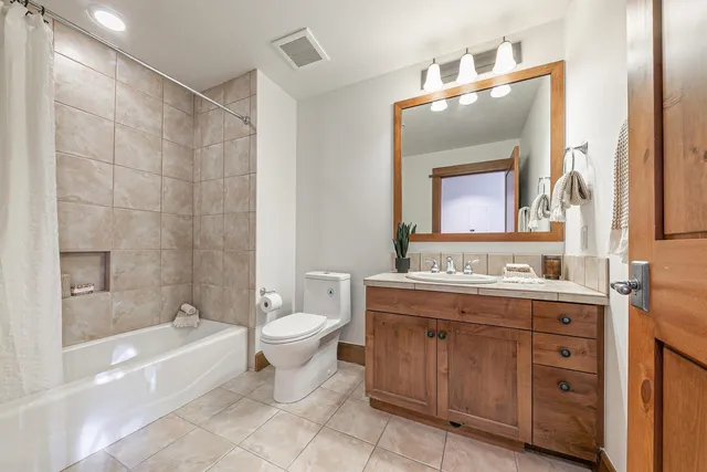a bathroom with a double vanity sink mirror bathtub and toilet