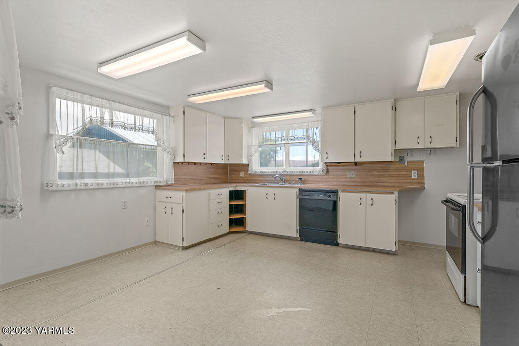 9206 Occidental Road Yakima, WA 98903 - Photo 3 of 23 a kitchen with white cabinets stainless steel appliances and a window