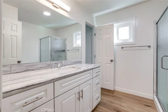 a bathroom with a granite countertop double vanity sink and mirror