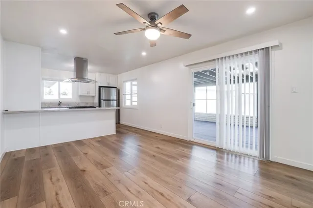 a view of a big room with wooden floor and a ceiling fan