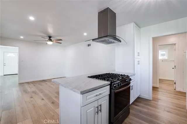 a kitchen with a stove and a wooden floor