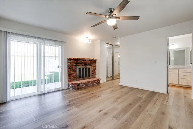 a view of a livingroom with wooden floor and a ceiling fan