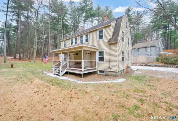 a view of a house with a yard and sitting area