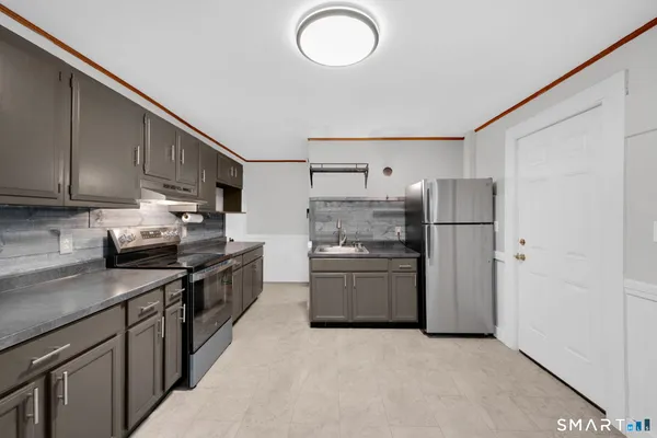 a kitchen with refrigerator and cabinets