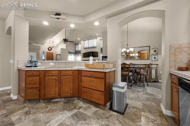 533 Talus Road Monument, CO 80132 - Photo 17 of 46 Kitchen with pendant lighting, dishwasher, ceiling fan with notable chandelier, vaulted ceiling, and kitchen peninsula