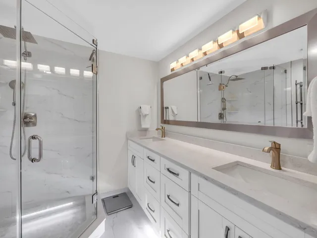 a bathroom with a granite countertop sink mirror and shower