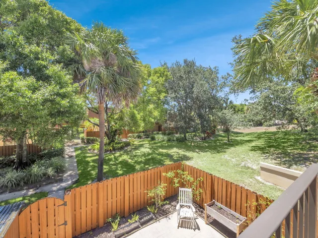 a view of a wooden deck and trees with wooden fence