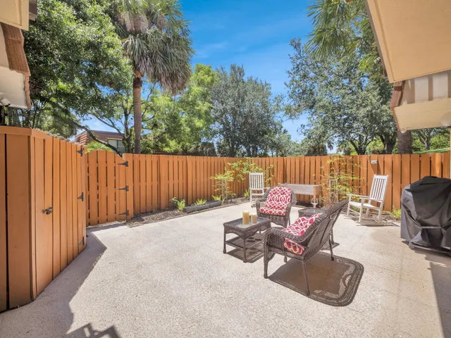a view of backyard with outdoor seating and trees