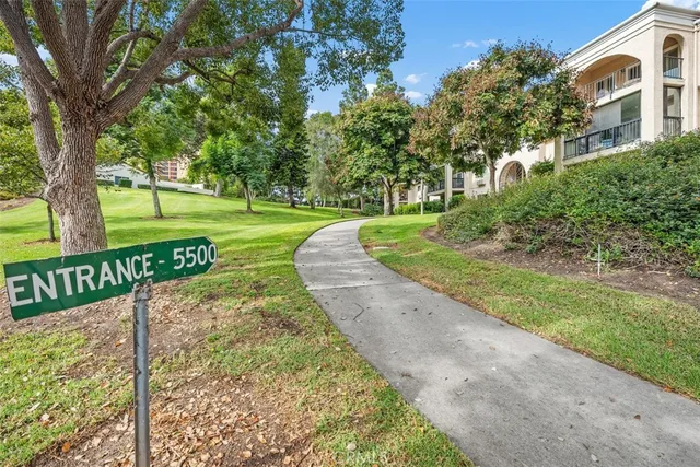 a view of a street with a bench and trees