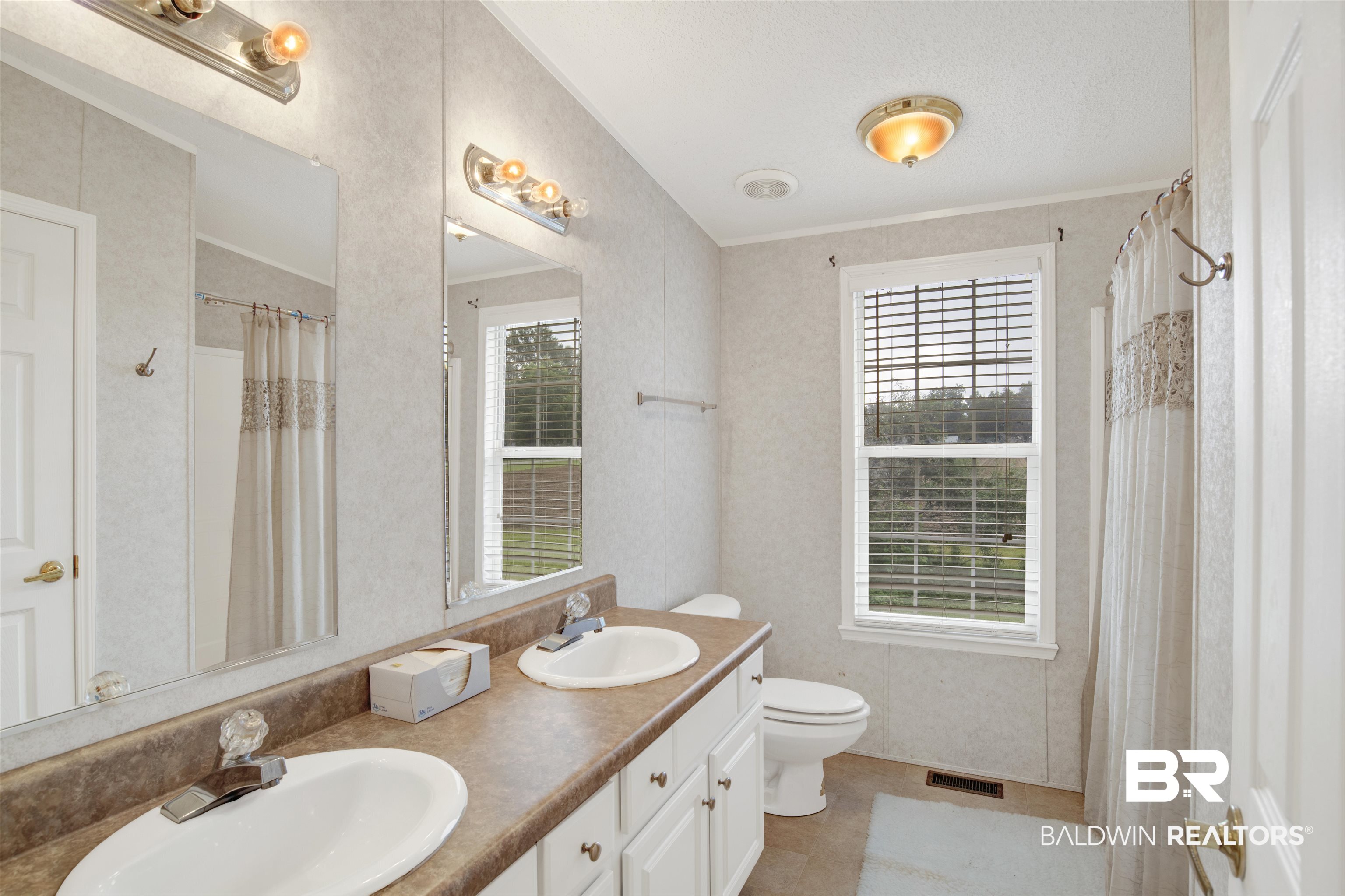 25700 County Road 71 Robertsdale, AL 36567 - Photo 17 of 40 Full bathroom with double vanity, a shower with curtain, and crown molding