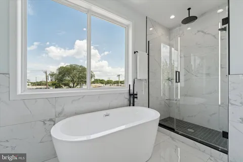 a white bath tub sitting next to a shower
