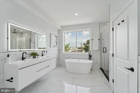 a en suite bathroom with a tub sink and mirror