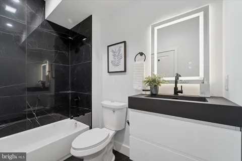 a bathroom with a sink a toilet a mirror and shower