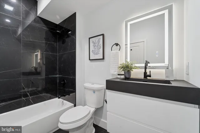 a bathroom with a sink a toilet a mirror and shower