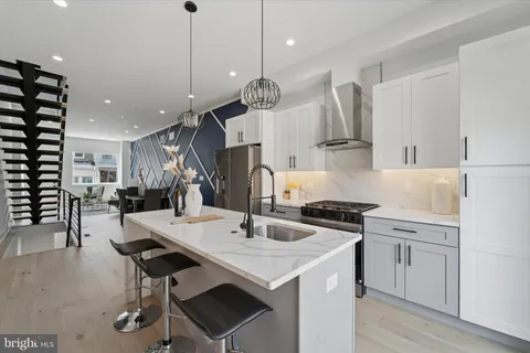 a kitchen with a sink a stove and chairs