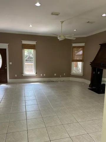 an empty room with windows and fireplace