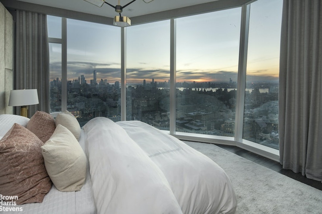 45 East 22nd Street, Unit 42A Manhattan, NY 10010 - Photo 9 of 23 a bed sitting in a bedroom next to a large window