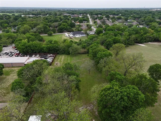 an aerial view of residential houses with outdoor space and trees