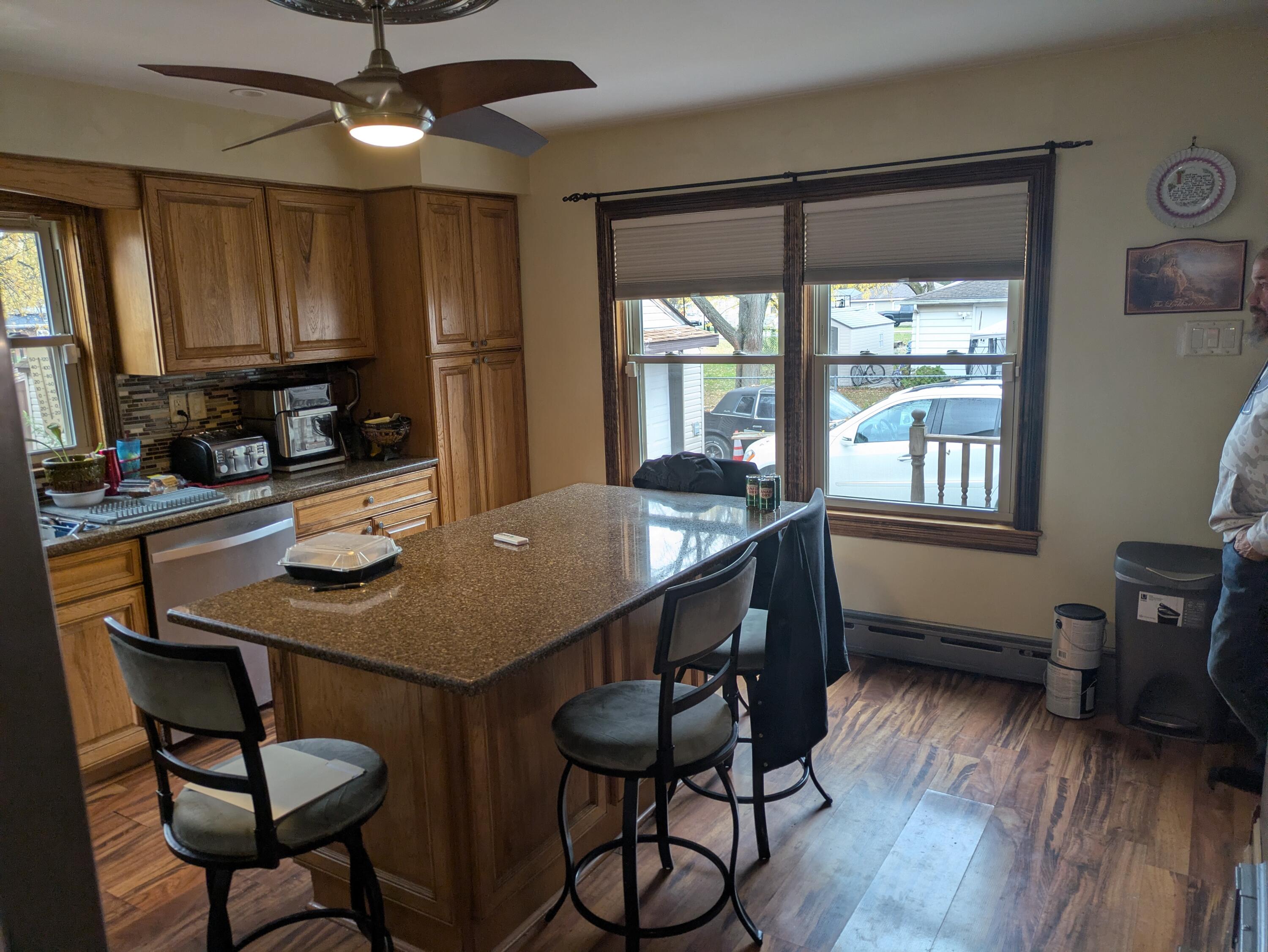 315 North Hobart Road Hobart, IN 46342 - Photo 4 of 33 a kitchen with stainless steel appliances kitchen island a table chairs in it and wooden floors