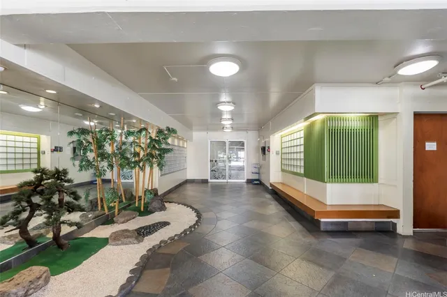 a lobby with furniture and potted plants