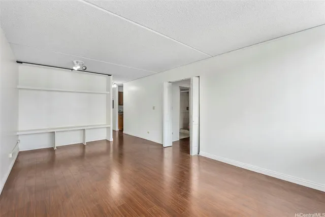 an empty room with wooden floor and window